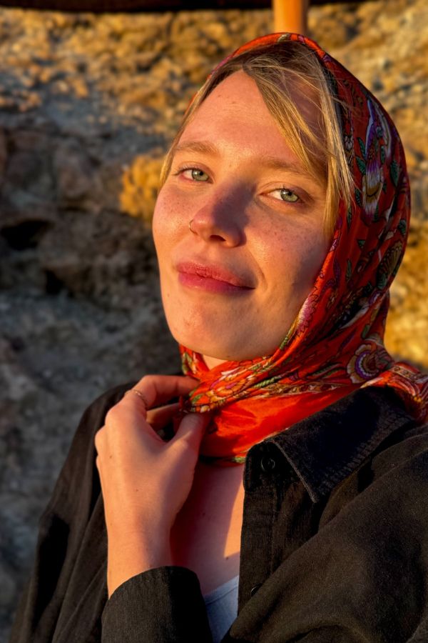 Ritratto di me al tramonto nel deserto di Agadir, vicino Marrakech, in Marocco. Indosso una camicia nera e un foulard rosso che richiama i toni caldi e dorati del cielo al tramonto, immersa nella magica atmosfera del deserto.